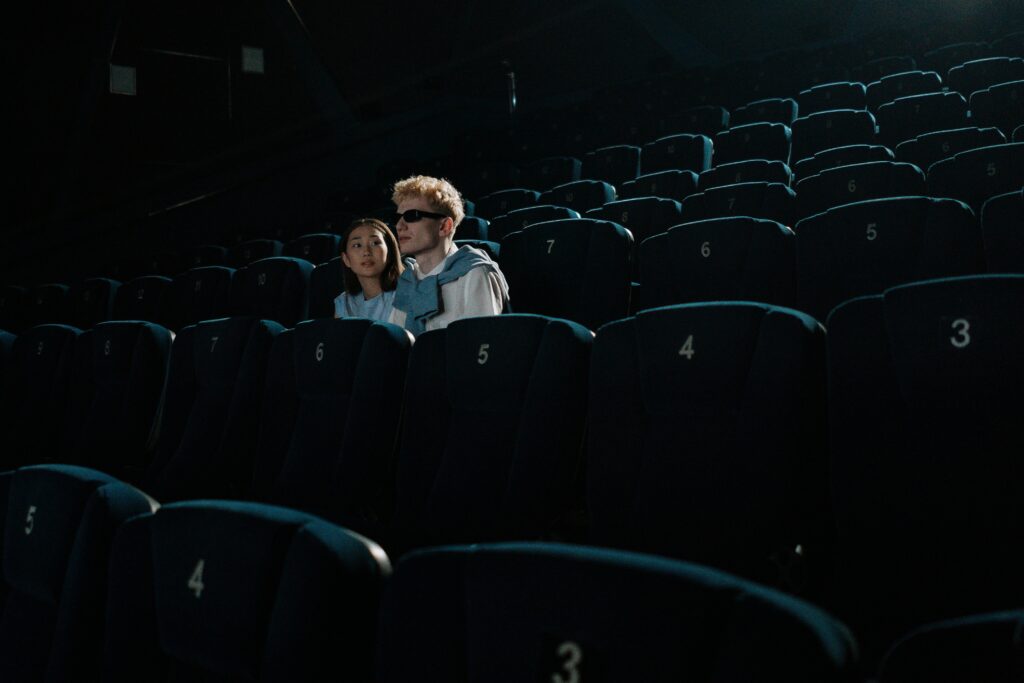 Photo d'une salle de cinéma vide, à l'exception de deux jeunes spectateurs